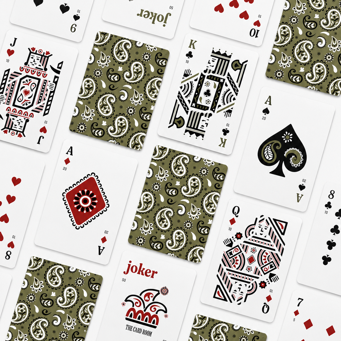 A flat-lay arrangement of playing cards from The Card Room, featuring both front and back designs. The cards display various suit icons, including hearts, spades, clubs, and diamonds, as well as the Joker and King of Spades.
